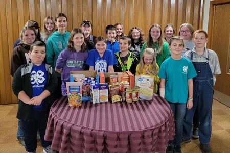 group of 4-H members and leaders with a collection of food donations