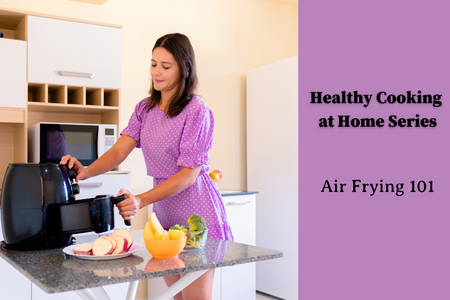 lady in purple dress using an air fryer in her kitchen with food prepped in front of it