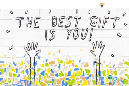 painting on brick with text the best gift is you with two arms reaching up