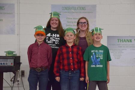 group of cloverbuds with graduation hats on