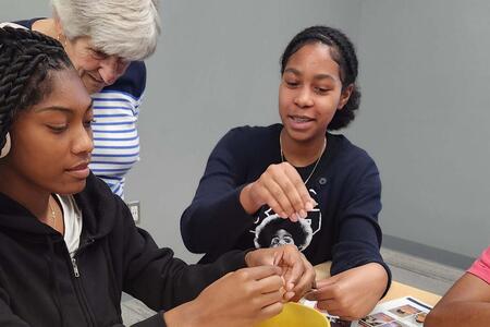 Master Gardener working on project with two teenage girls