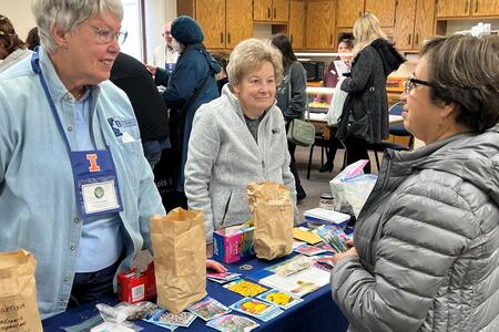 women discussing seeds with seed packets on table