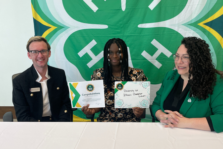 A youth smiles at signing day with 4-H leadership.