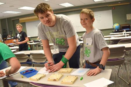 two boys working over a table