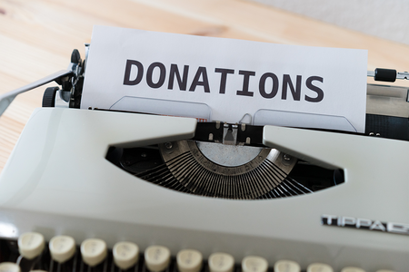 vintage grey typewriter with paper saying Donations on it