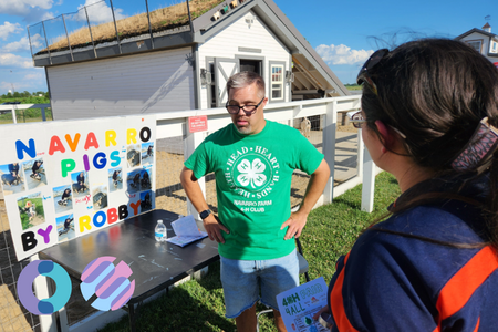 A 4-H member shows off his project about pigs