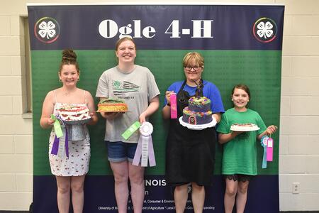 Four youth with cakes and ribbons