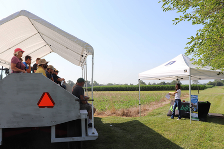 A presenter shares information on agriculture research at a field day presentation.