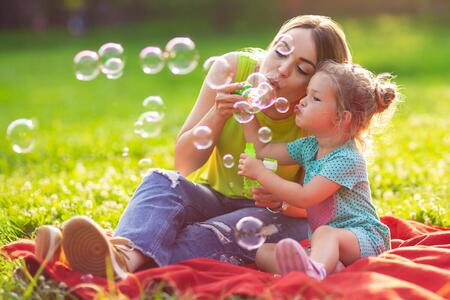 A woman and a girl playing with bubbles