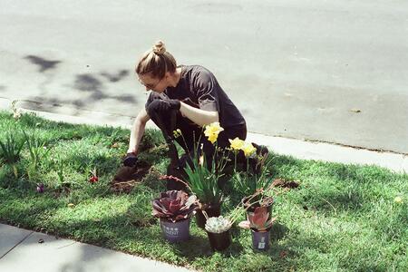 lady kneeling on ground planting a flower