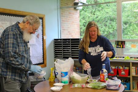 Bob Chinn, founder of the Mary M. Chinn Charitable Corporation, and Shasta Hladovcak, 4-H Youth Development Educator, prepare salad ingredients for the class. 