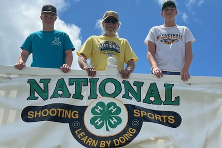 Participants and coach pose by National banner.