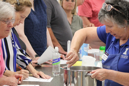 class participants watching a canning demonstration