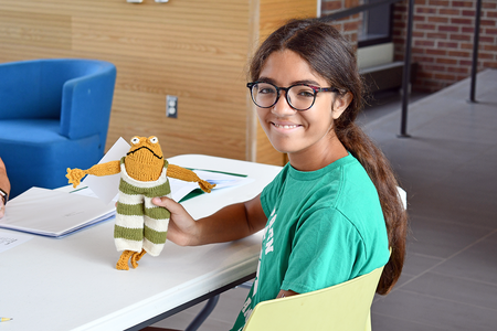 A 4-H'er displaying her project of a woven toad