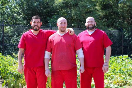 Jovanny Castaneda, Hallan Brady, and Derek Hornick pose in front of their garden