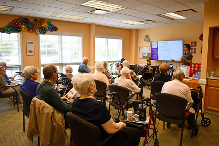 Crowd of class participants listen to presentation on signs of Alzheimer's