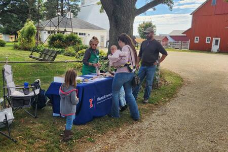 People standing at an Extension informational table