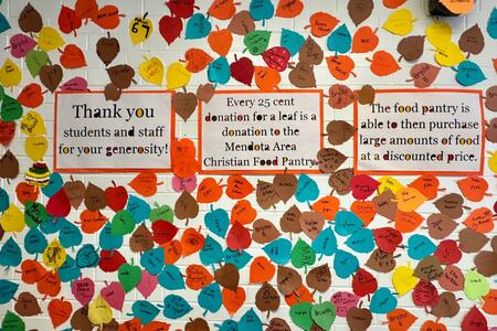 Colorful paper leaves and signage that explains the fundraiser displayed at Northbrook Middle School