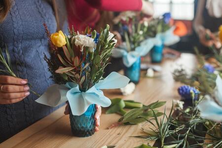 flower design class, hands inserting flowers into a vase