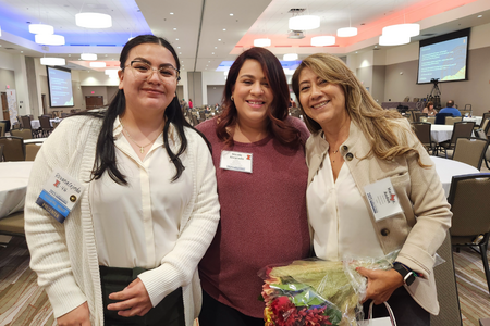 Three people smile for the camera