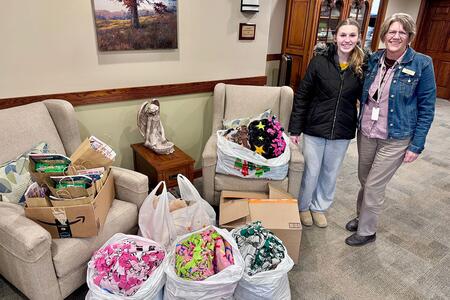 Two people standing next to bags of blankets