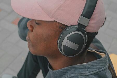 person wearing pink baseball cap and black headphones