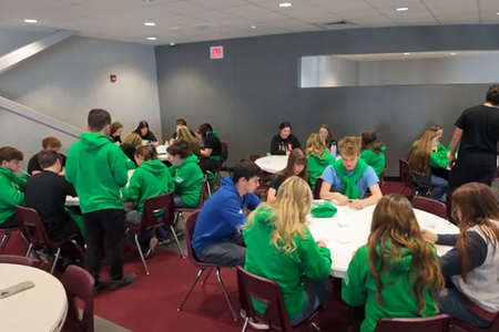 Teens work at tables during a Teen Teacher training.