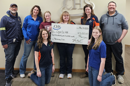 group of adults standing with big check