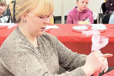 Kaylee Grebner demonstrating cake decorating
