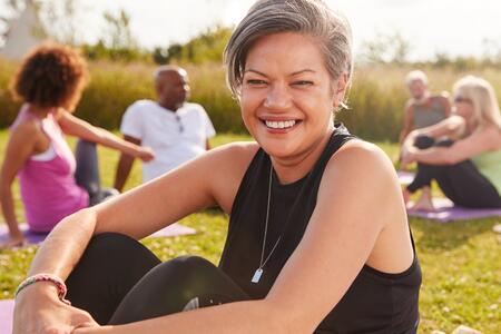 A woman smiling and exercising outdoors
