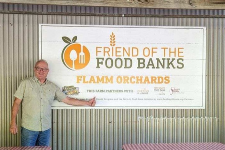 A person pointing to a sign that reads: Friend of the Food Banks