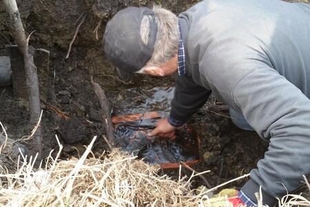 a farmer clearing a field drain