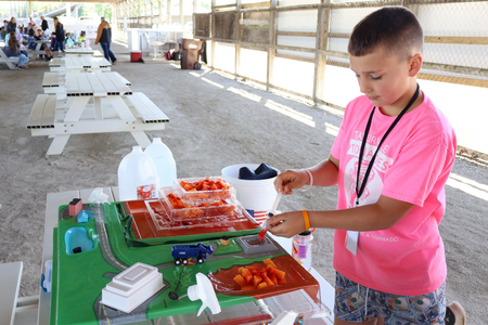 A student explores how waste moves through a landfill system using a hands-on model.