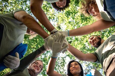 A gorup of people in a forest with connected hands