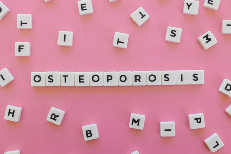 Osteoporosis spelled out in beads on a pink background