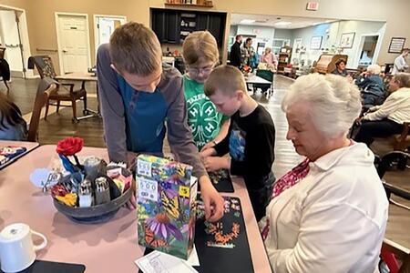 4-H member working on puzzle with lady