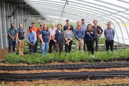 A group of people stand in a greenhouse