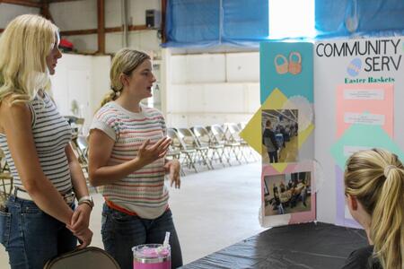 Federation members Karlie Schultz and Lydia Hardy explain their Service Learning project to the judge.