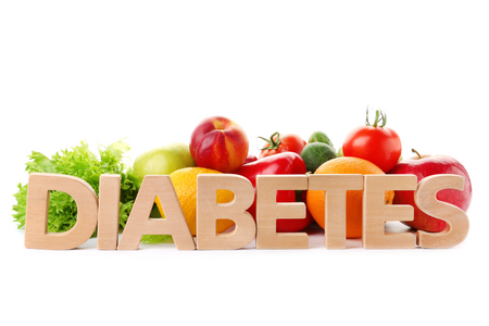 Diabetes word with fruits and vegetables int he background