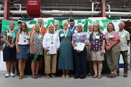 group of people standing in front of a 4-H backdrop