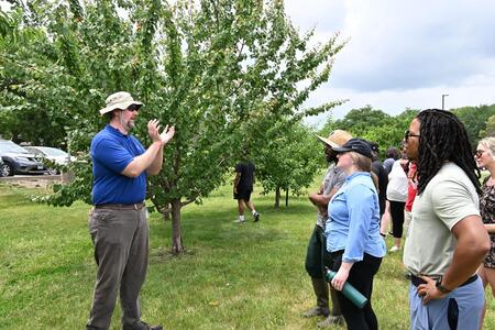 Dr. John Fisher teaching in an orchard