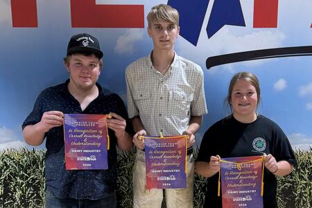 three youth holding award banners