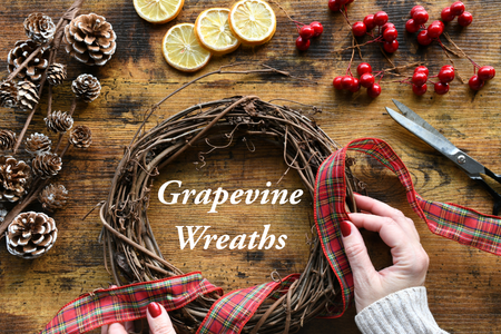 making a grapevine wreath with pine cones, ribbon, lemon slices and berries