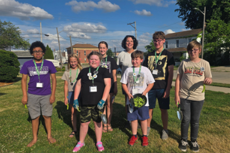 Group of youth standing outside on grass smiling