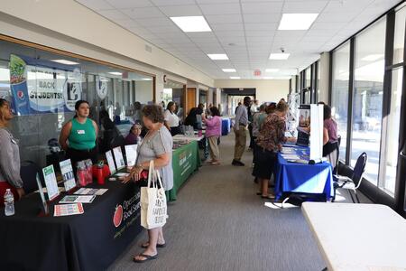 People hoisting walk-by booths with participants speaking to them at the food security summit.