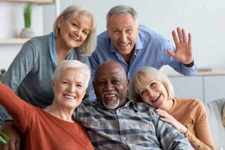 Group of elderly friends smiling and sitting together