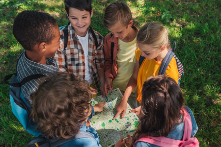 Kids standing in a circle looking at a map