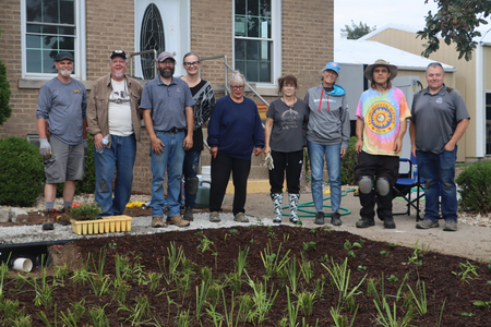 Rainscaping class members standing by the newly planted rain garden.