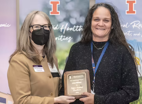 Extension staff member White receiving award from director