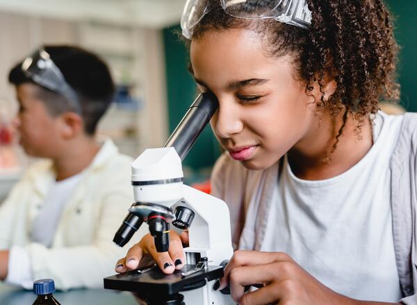 elementary age student looking into a microscope